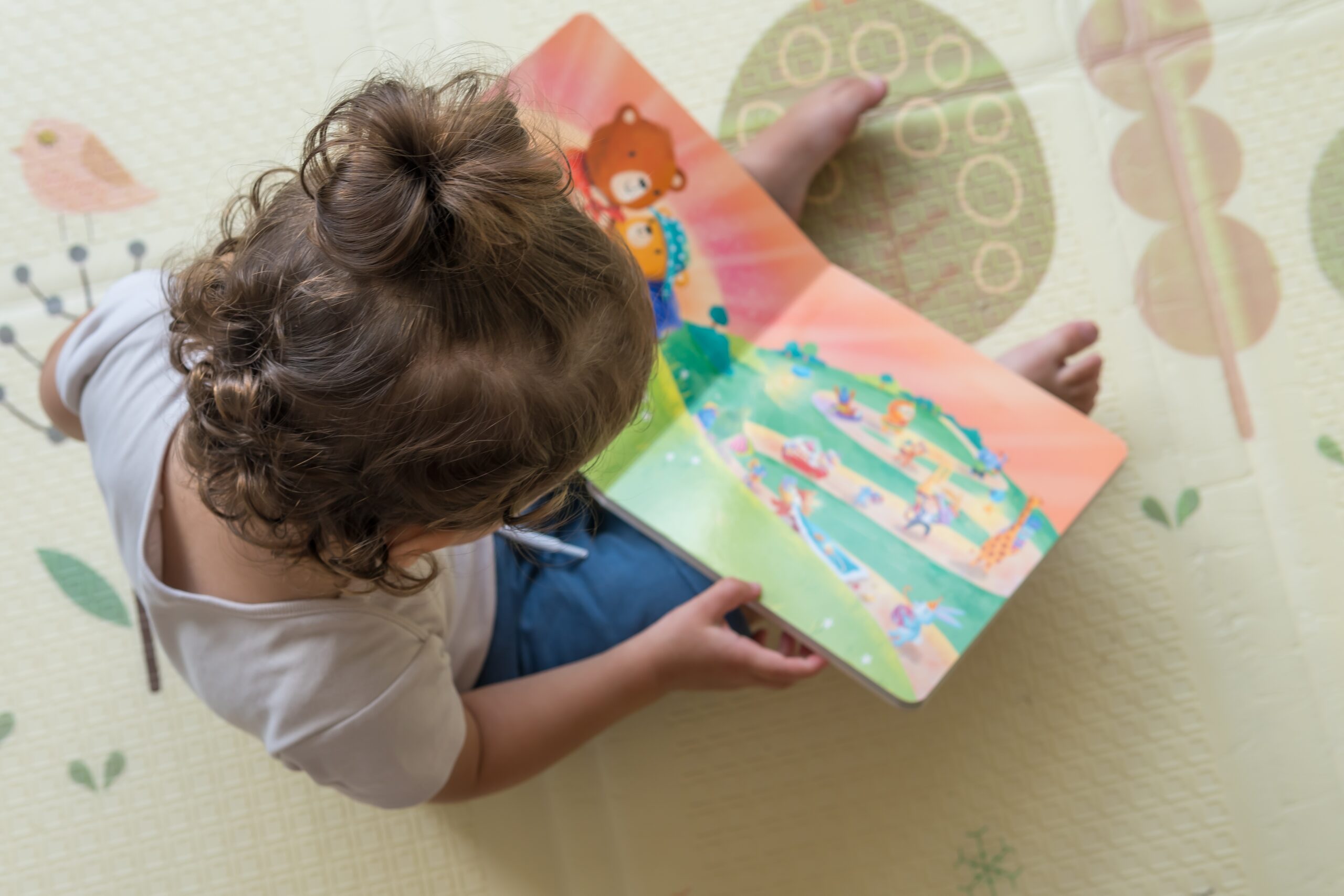 Infant,Sitting,On,A,Playmat,And,Reading,A,Coloful,Children’s Infant care at Bethany Academy